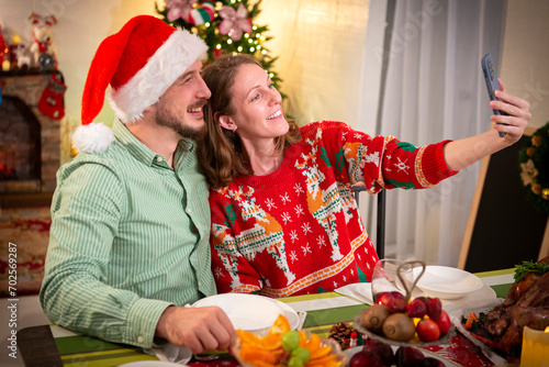 Young couple taking a selfie at a Christmas party at home