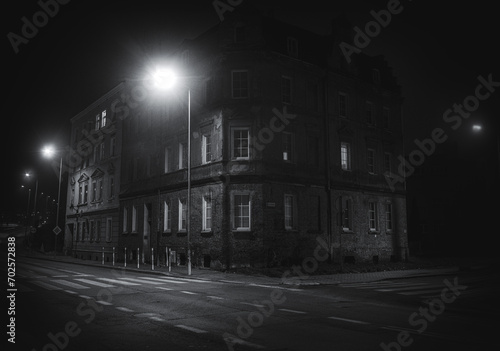 ciemne zaułki starego miasta z latarnią w mroku photo