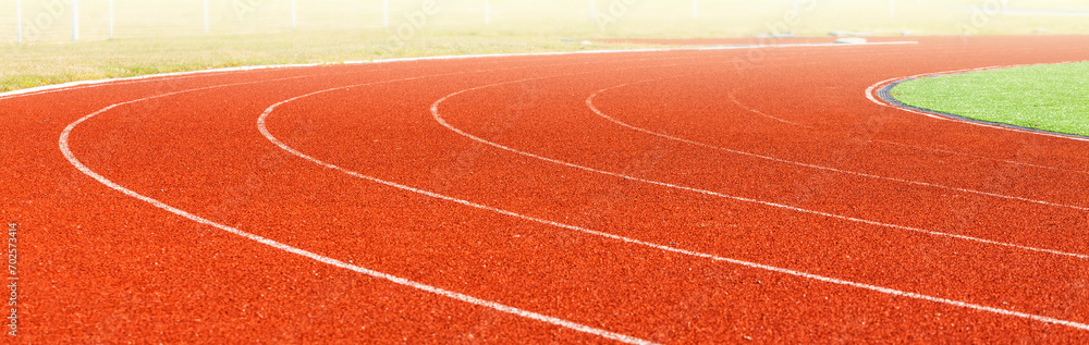 Fototapeta premium Turn on the red racetrack at the stadium on sunlight