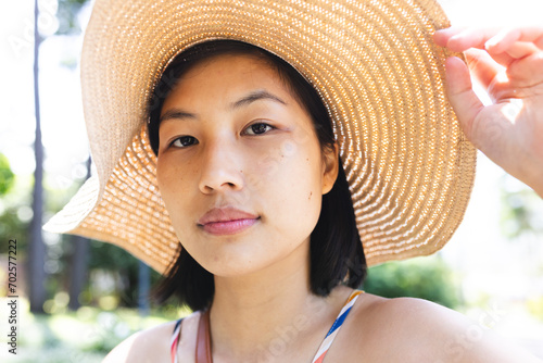 Portrait of asian woman with short hair wearing sunhat in garden at home photo