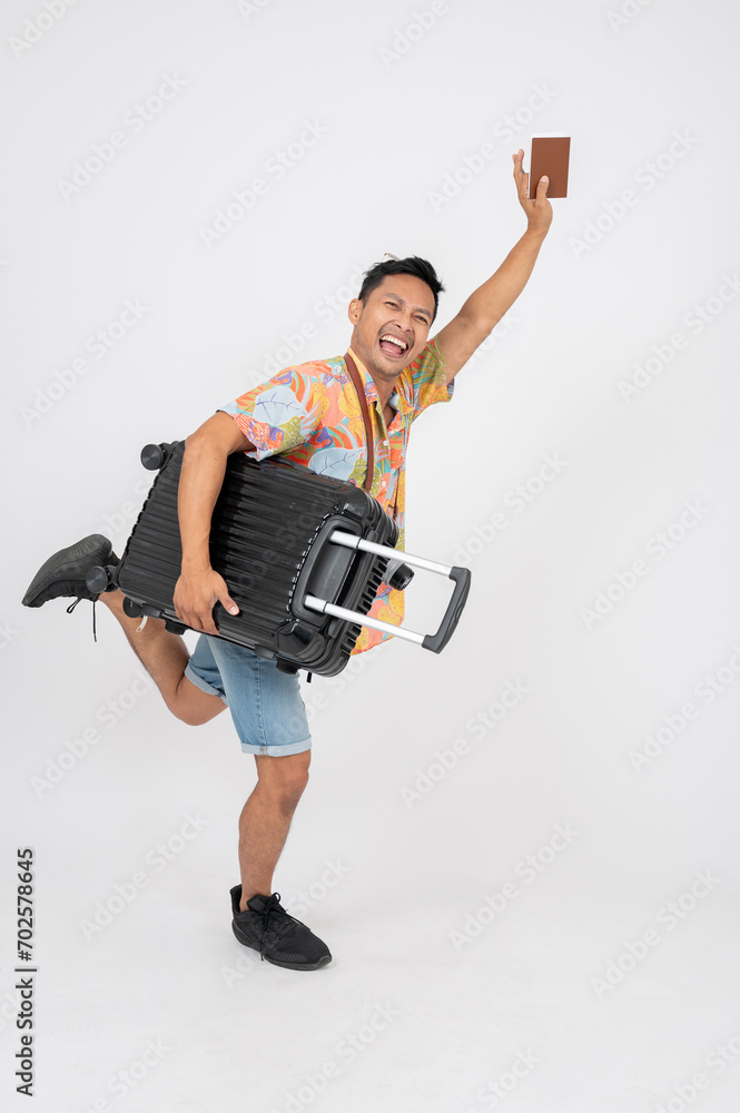 A fun, excited Asian man tourist in summer clothes is jumping with his passport and luggage. A fun, excited Asian man tourist in summer clothes is jumping with his passport and luggage.