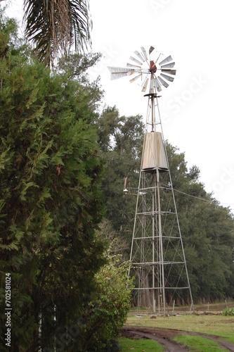 A windmill in the countryside next to a road
