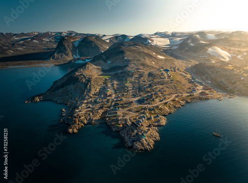 Sunlit Isolation: Aerial View of Ittoqqortoormiit, Greenland's Remote Settlement (ID: 702581231)