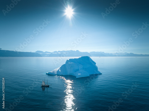 Arctic Adventure: Sailing Amidst Greenland's Glaciers on a Sunlit Day - Aerial Drone View (ID: 702581254)