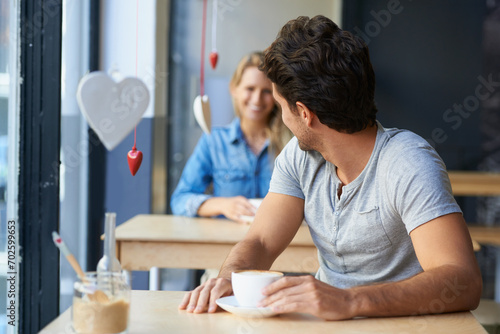 Back, flirting or happy man in cafe with a coffee to relax with smile, morning espresso or crush. Face, romance or person looking with tea, cappuccino or woman with love, peace or calm in restaurant photo