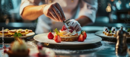 The pastry chef is completing a dessert in a hotel or restaurant kitchen. photo