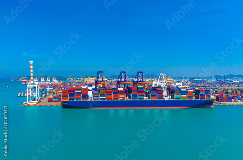 Aerial side view of cargo ship carrying container and running for export goods from cargo yard port to custom ocean concept technology transportation , customs clearance.