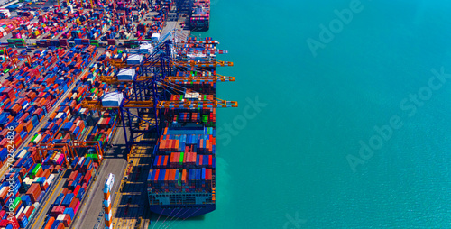 Global transportation and logistic business. Aerial top view over international containers cargo ship at industrial import-export port prepare to load containers with big container loader ship.
