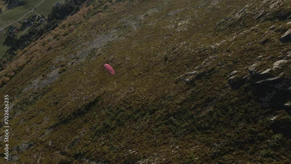 Aerial top down shot of paraglider flying over green mountains at sunny day in Norway Aerial top down shot of paraglider flying over green mountains at sunny day in Norway