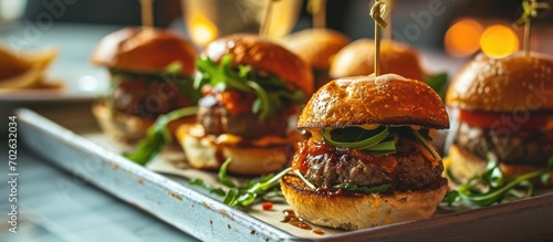 Tiny hamburgers placed on a plate for a event.