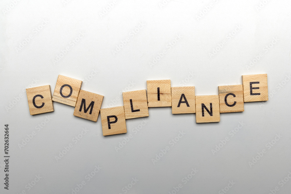 Obraz premium A row of wooden cubes with compliance letters