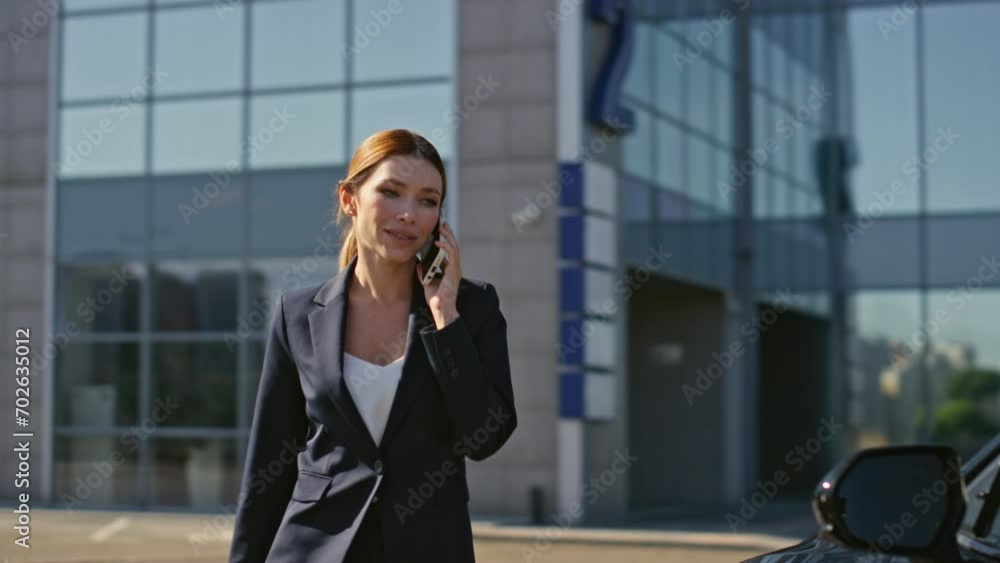 Luxurious businesswoman talking mobile phone getting in expensive car at street Luxurious businesswoman talking mobile phone getting in expensive car at street