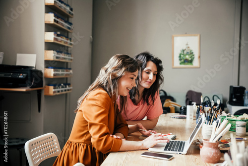 Business discussion. Two attractive young female employees discussing their small business in the workshop.