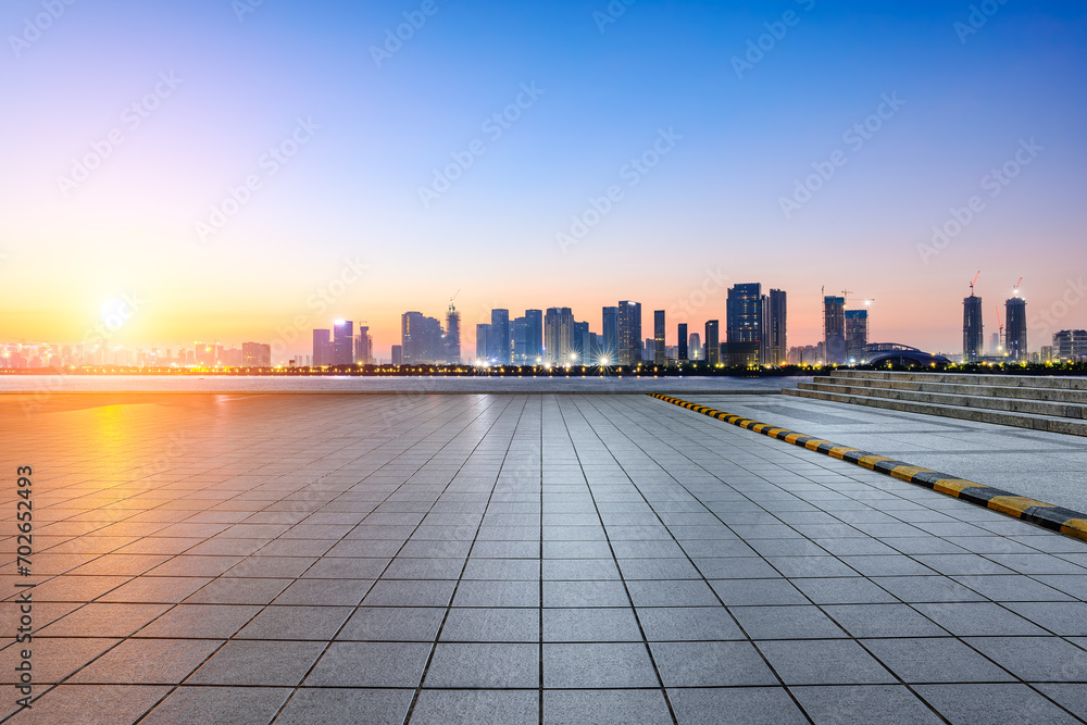 Empty square floor and city skyline with modern buildings at sunrise