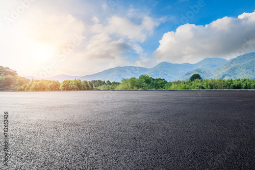 Asphalt road square and green forest with mountain natural landscape under blue sky photo