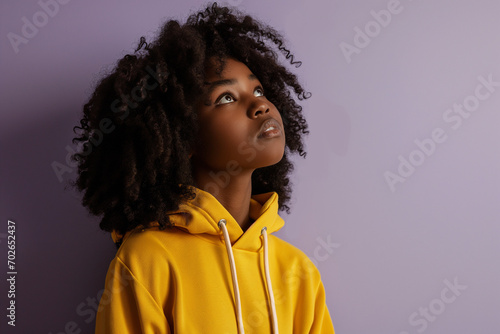 African American serious teenage girl wearing hoodie on purple background