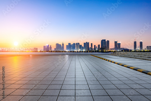 Empty square floor and city skyline with modern buildings at sunrise © ABCDstock