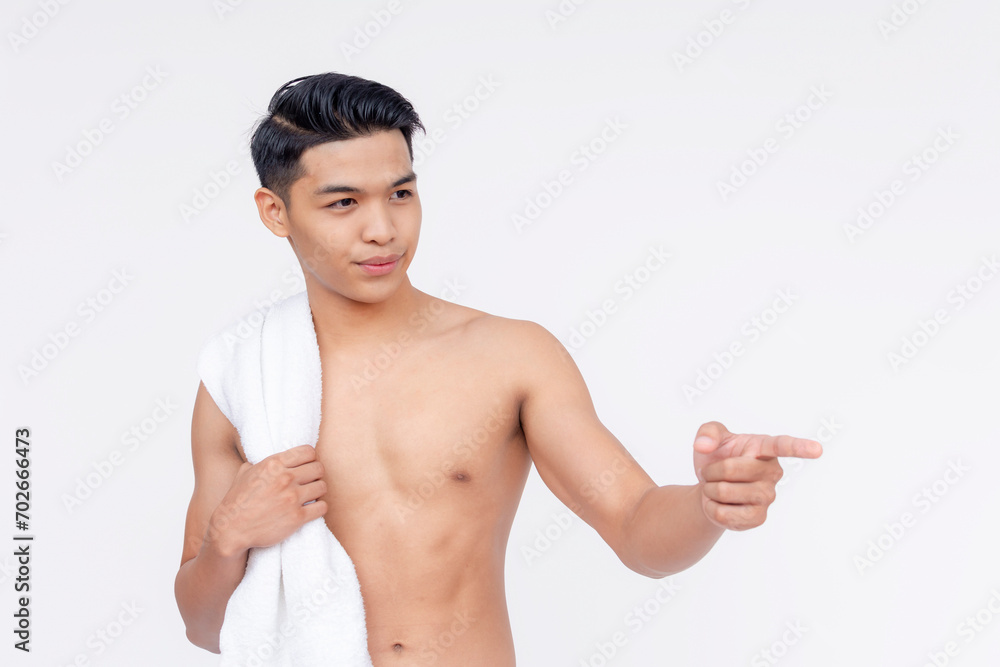 A young asian man with a towel wrapped around his neck, pointing to the right. Isolated on a white backdrop. A young asian man with a towel wrapped around his neck, pointing to the right. Isolated on a white backdrop.