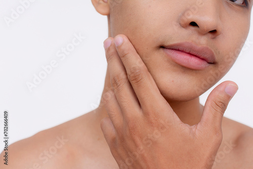 Partially cropped shot of a handsome young babyfaced man stroking his smooth chin. Isolated on a white backdrop. photo