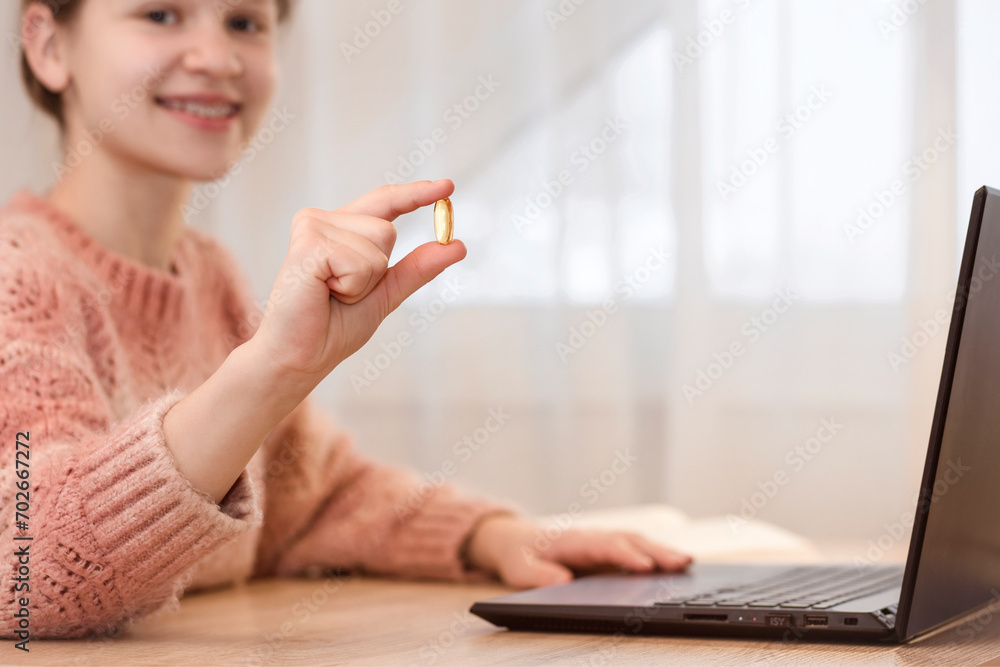 Omega for Studying Children. Student Girl Teenager Holding Omega 3 Vitamin Pill Close up Using Laptop. - obrazy, fototapety, plakaty 
