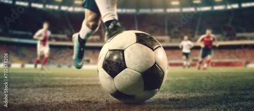 Soccer player's feet kick the soccer ball for kick - off in the stadium