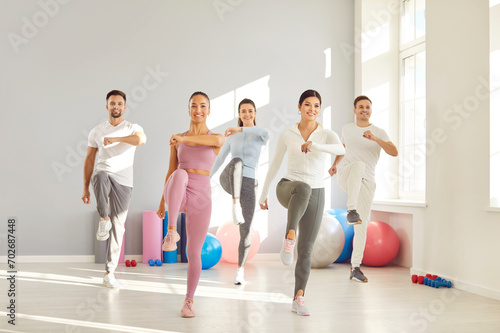 Happiness and collaboration as a group of sport people engages in a fitness session or exercise at the gym. The atmosphere is filled with smiles and positive energy, showcasing the teamwork.