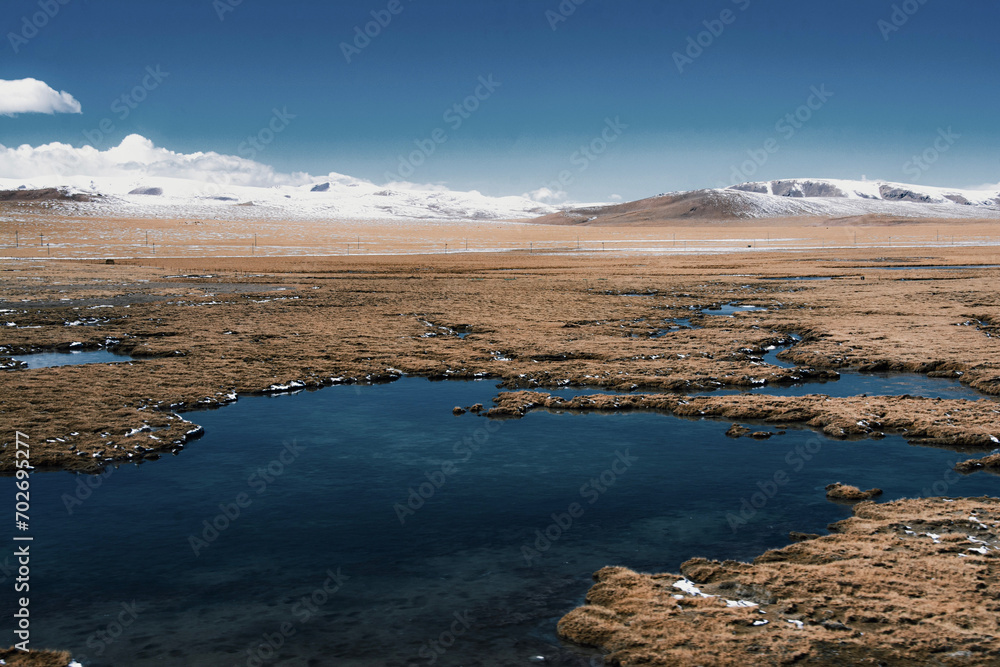 Picturesque landscape featuring a tranquil body of water with snow-capped mountains.
