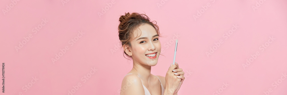 Makeup artist applies eyeshadow powder with brush for young woman.