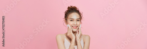 Gorgeous young asian woman holding cotton pads and smiling. Skincare and hygiene concept photo
