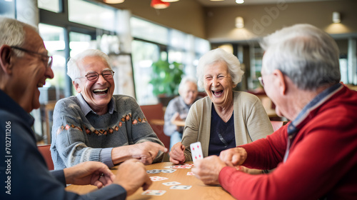 Joyful group of seniors playing cards and laughing in a retirement nursing home
