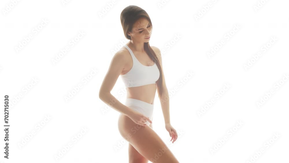 Beautiful woman in white underwear over isolated white background. Studio video of healthy young girl in swimsuit. Health and skin care, wellness, dieting and cosmetics concept.