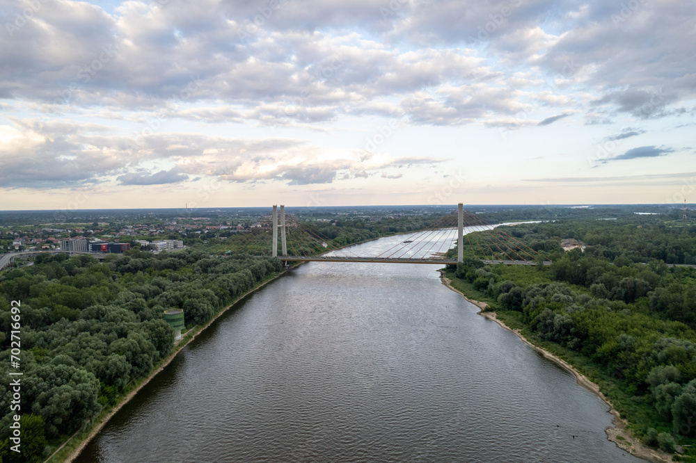 Captured by drone, the aerial view of the Vistula River in Warsaw reveals the majestic Siekierkowski Bridge in the foreground.