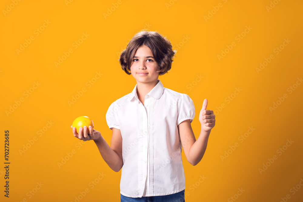 Girl holds an oranges in hand and shows thumbs up gesture. Healthy food and children nutrition concept Girl holds an oranges in hand and shows thumbs up gesture. Healthy food and children nutrition concept