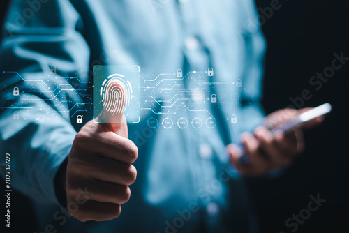 Cybersecurity and privacy to protect data. Businessman use smartphone to scan fingerprint for biometric authentication and cyber security. Access to personal information and secure internet access photo