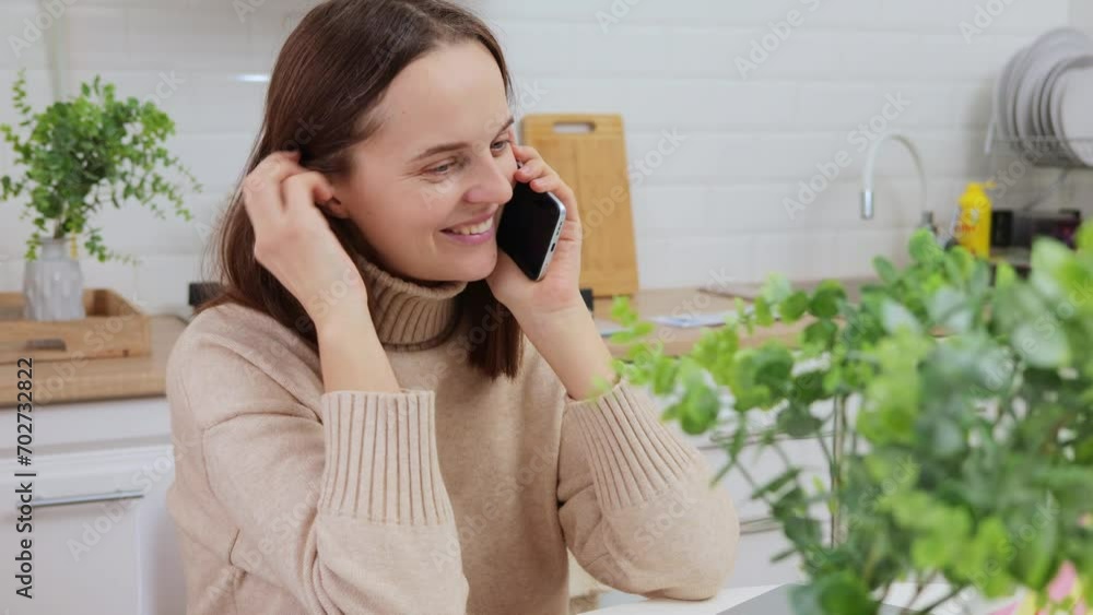 Smiling young woman working from home give remote phone consultation to client speaking by cell hold gadget sharing good idea solution with colleague or gossiping with friend Smiling young woman working from home give remote phone consultation to client speaking by cell hold gadget sharing good idea solution with colleague or gossiping with friend