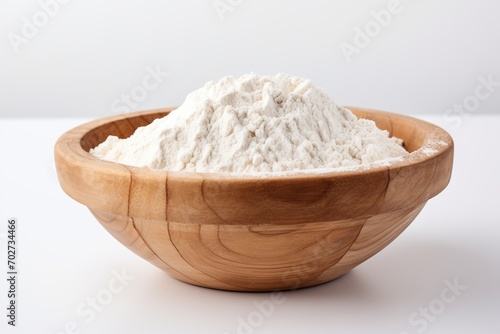 Flour in wooden bowl on white background