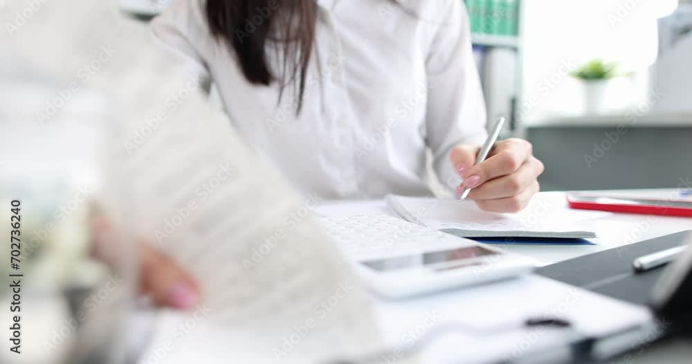 Business woman is counting on calculator and holding documents in hands at workplace. Accounting and business budget concept Business woman is counting on calculator and holding documents in hands at workplace. Accounting and business budget concept