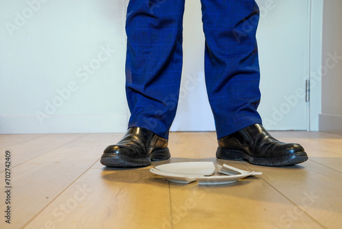 Businessman with a broken plate on the floor