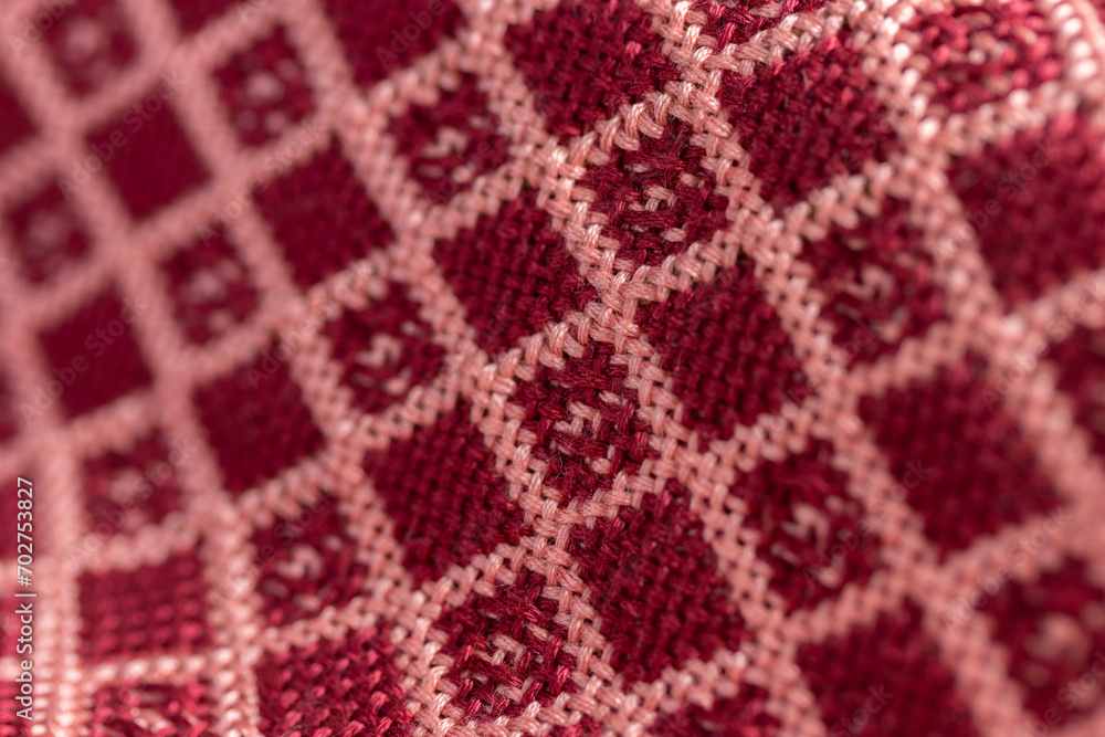 draped woven double cloth in red and pink geometric, diamond grid pattern, close up macro detail shot with shallow depth of field