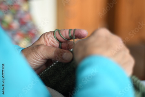 Closeup of woman hands knitting with green yarn