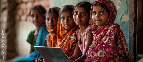 Rural girls receive online education with a laptop. photo