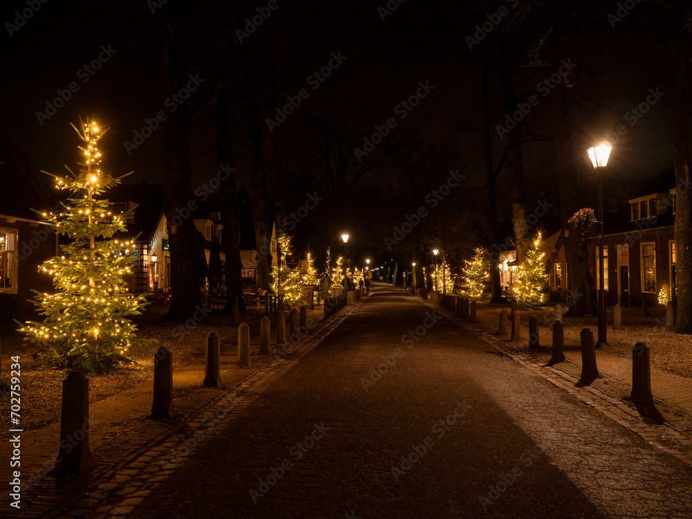 Festive Radiance: Christmas Lights Adorning Trees in the Night Streets of Lage Vuursche, Netherlands