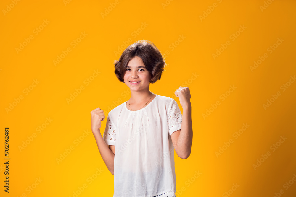 Smiling kid girl showing success over yellow background. Luck concept Smiling kid girl showing success over yellow background. Luck concept