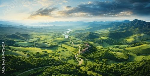 Aerial shot of a winding road in a green country countryside.