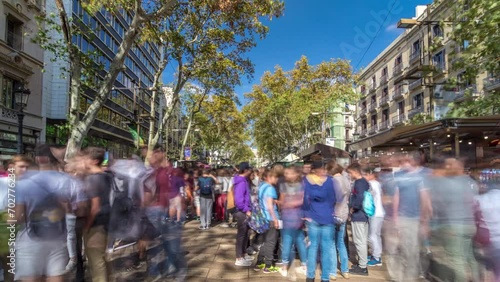 Timelapse Hyperlapse of the Iconic La Rambla Street in Barcelona, Spain. Thousands of Daily Strollers Contribute to the Dynamic Tapestry of this Popular Pedestrian Area photo