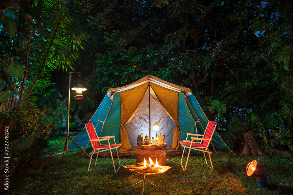 vintage cabin tent,  Antique oil lamp, retro chairs, Group of camping tents with outdoor coffee-making facilities on wooden tables in a forest camping area in the forest.