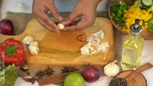 Woman Cutting Fresh Garlic on Wooden Cutting Board