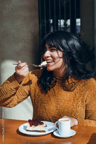 young woman celebrating women's day happy eating cheesecake