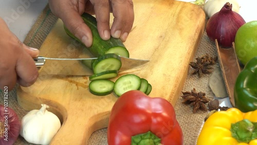 Cutting cucumber on a wooden chopping board