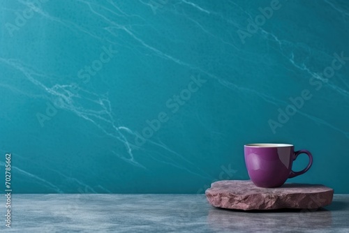  a purple coffee cup sitting on top of a rock next to a teal green wall with a marble slab in front of it.